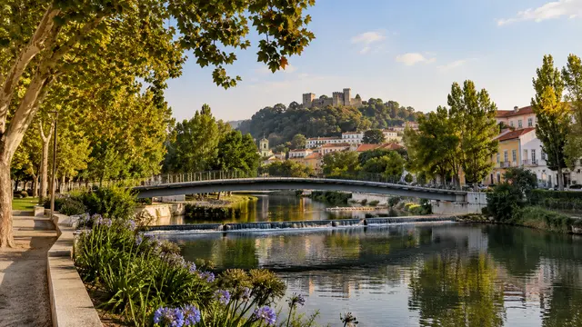 Leiria-inspired small-city river park with a pedestrian bridge.