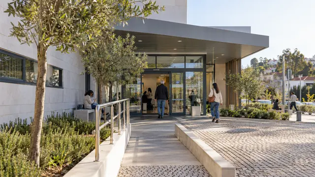 A welcoming contemporary Portuguese health-centre entrance with accessible path.