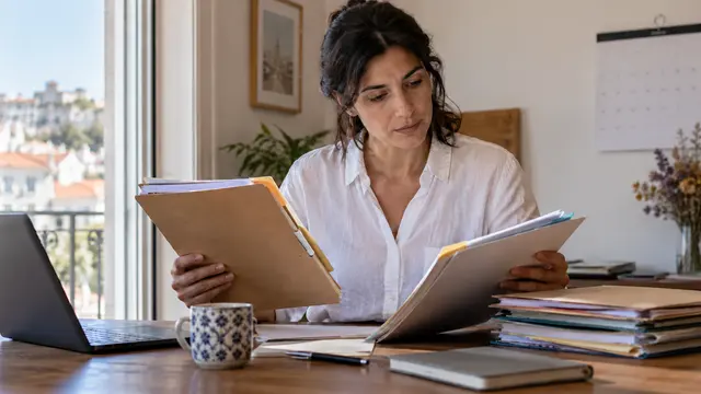 A professional reviewing older and newer document folders with different coloured tabs.
