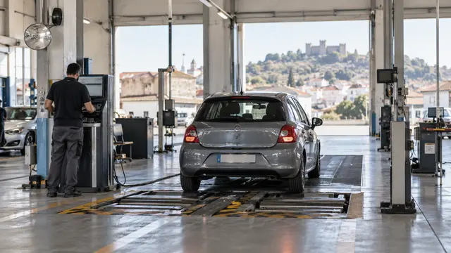A vehicle inspection workshop with a compact car on a safe testing lane.