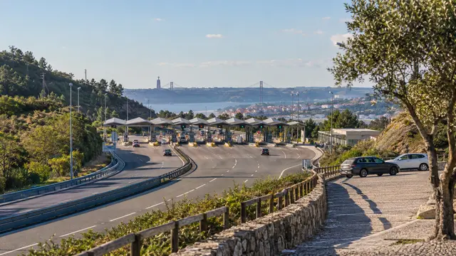 A Portuguese motorway toll approach seen from a safe distant roadside perspective.