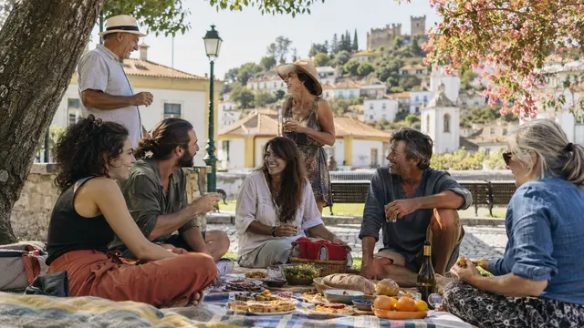 Neighbours sharing a casual community picnic in a small Portuguese park.
